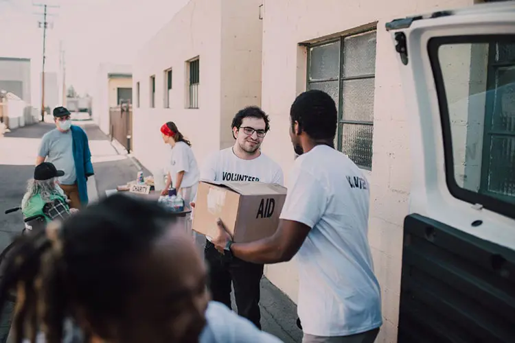 Nonprofit volunteers loading donation boxes into a van